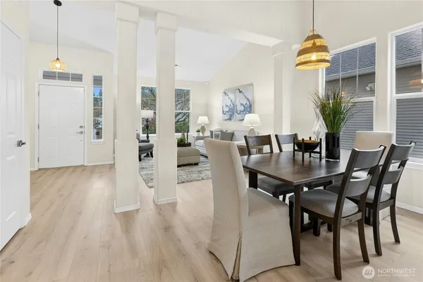 a dining room with furniture potted plants and wooden floor