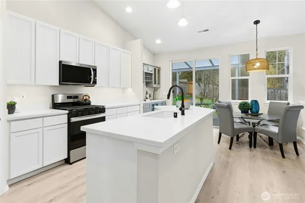 a kitchen with a sink cabinets and wooden floor
