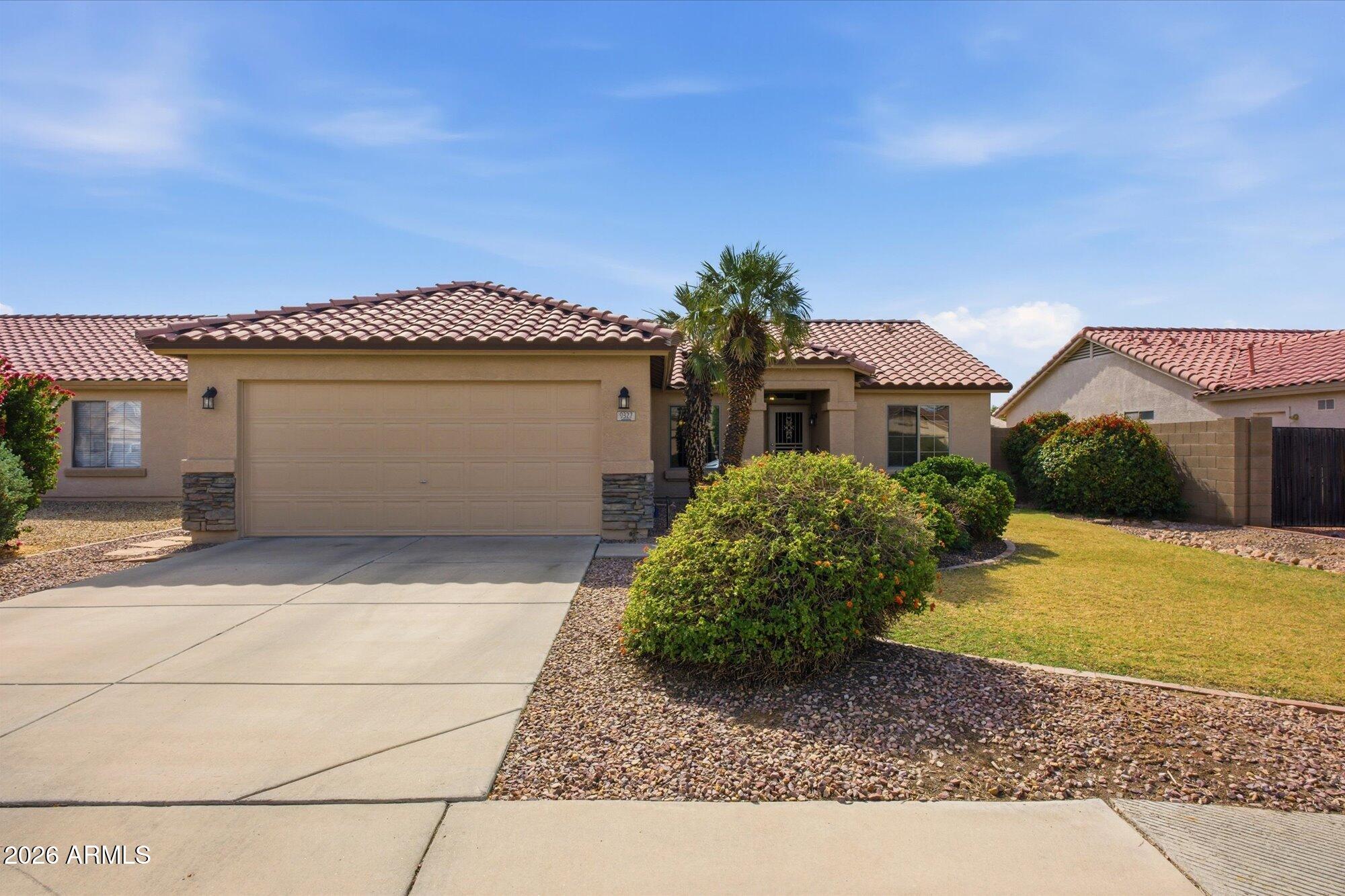9327 West Mountain View Road Peoria, AZ 85345 - Photo 28 of 30 a front view of a house with a yard and garage