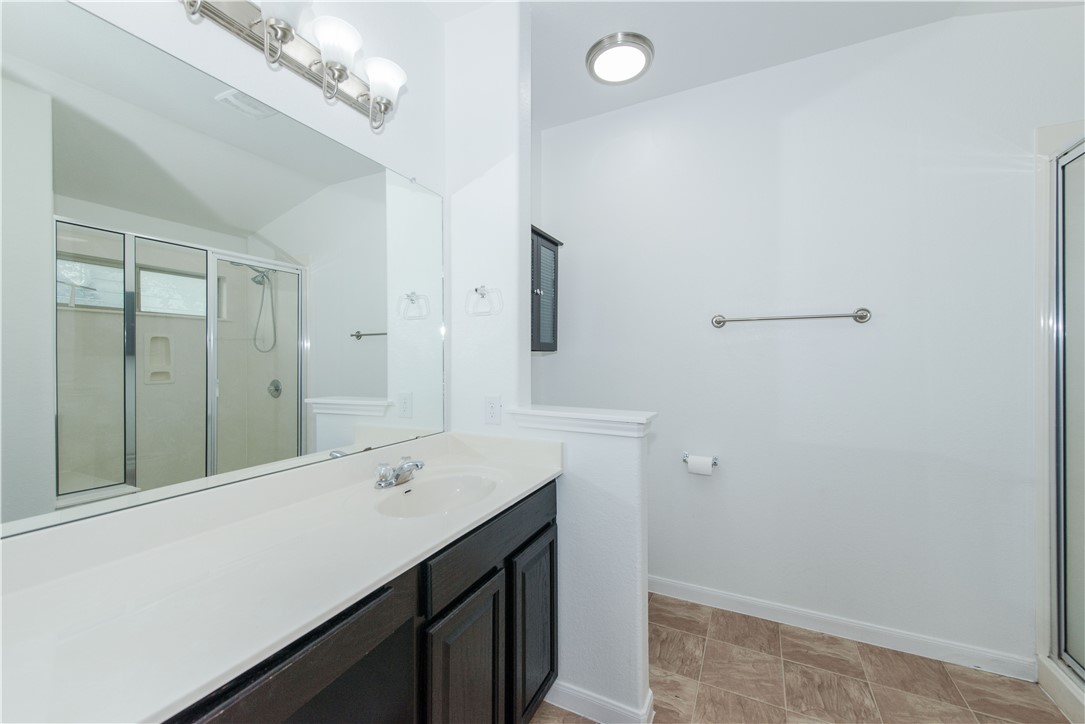 1007 Plateau Trail Georgetown, TX 78626 - Photo 16 of 32 a bathroom with a sink a mirror and a shower