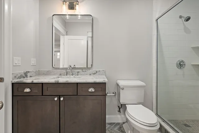 a bathroom with a toilet a sink and mirror