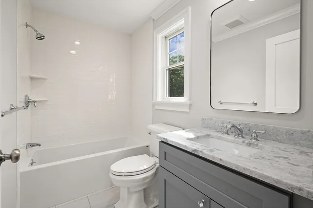 a bathroom with a granite countertop sink a toilet and shower