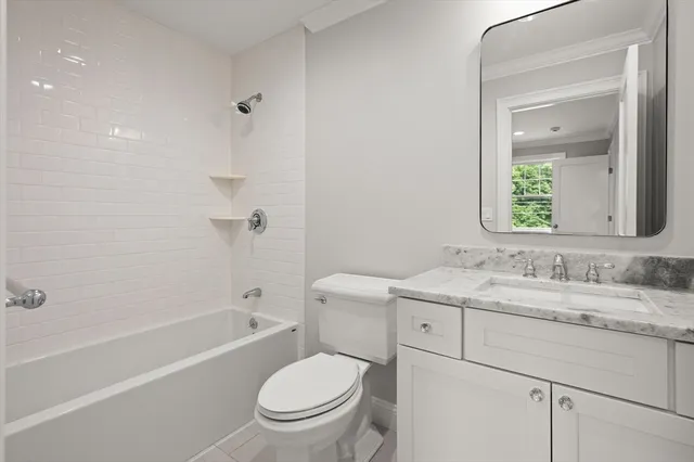 a bathroom with a granite countertop toilet a sink and a bathtub