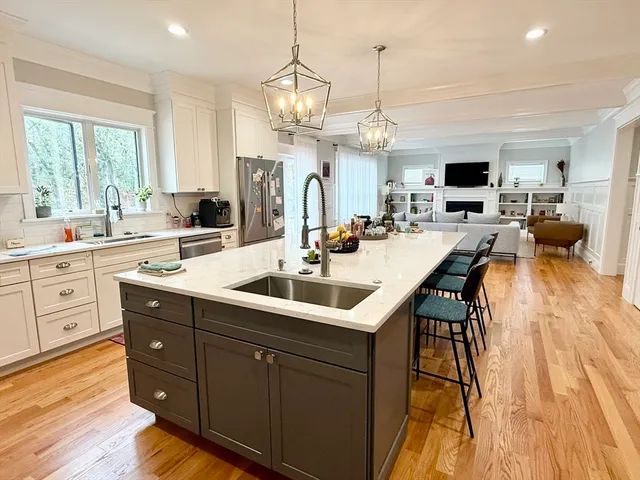 a kitchen with a sink stove and wooden floor