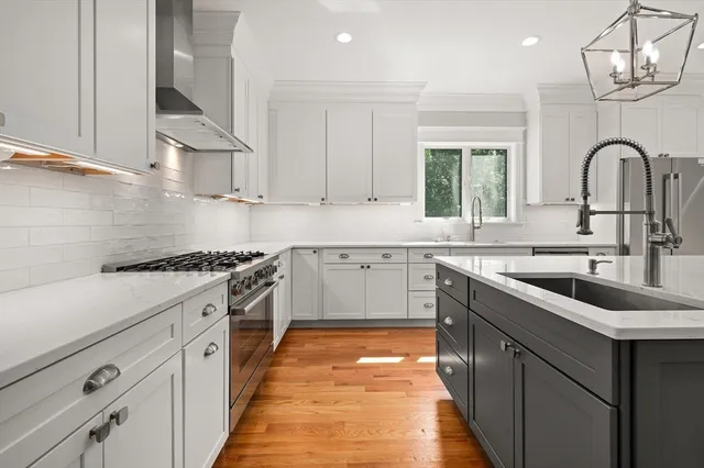 a kitchen with granite countertop a sink stainless steel appliances and cabinets