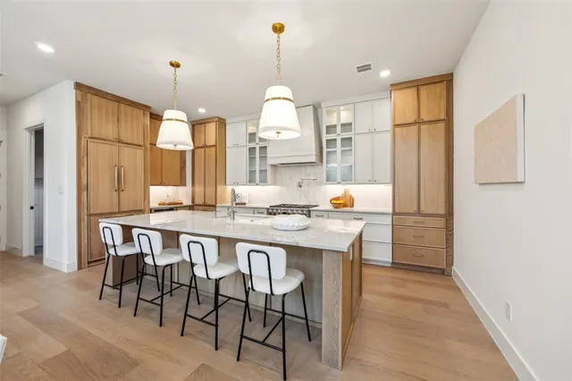 a dining hall with stainless steel appliances granite countertop wooden floor a refrigerator and a view of living room