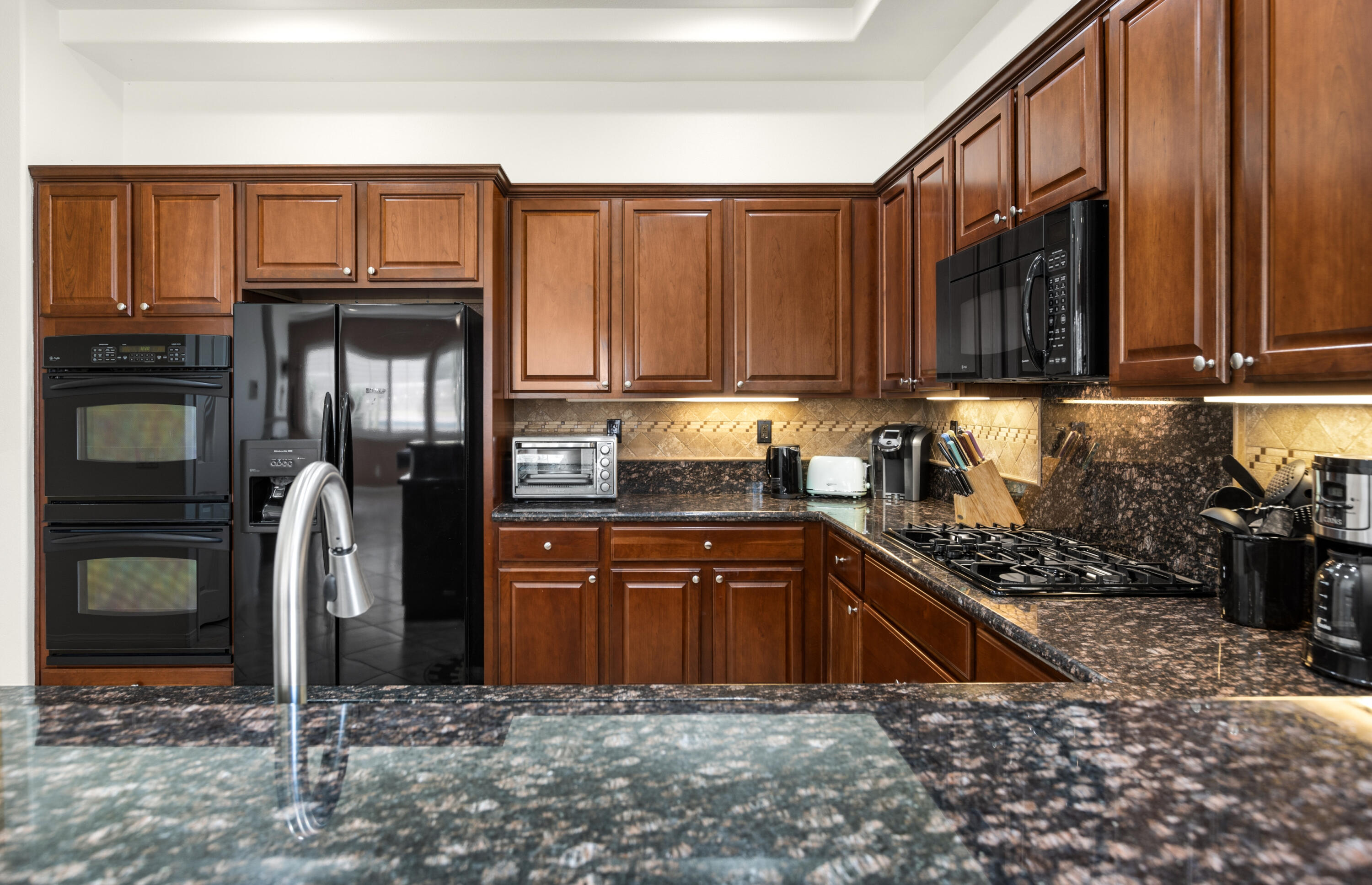 43760 Spiaggia Place Indio, CA 92203 - Photo 15 of 38 a kitchen with stainless steel appliances granite countertop a refrigerator stove and sink