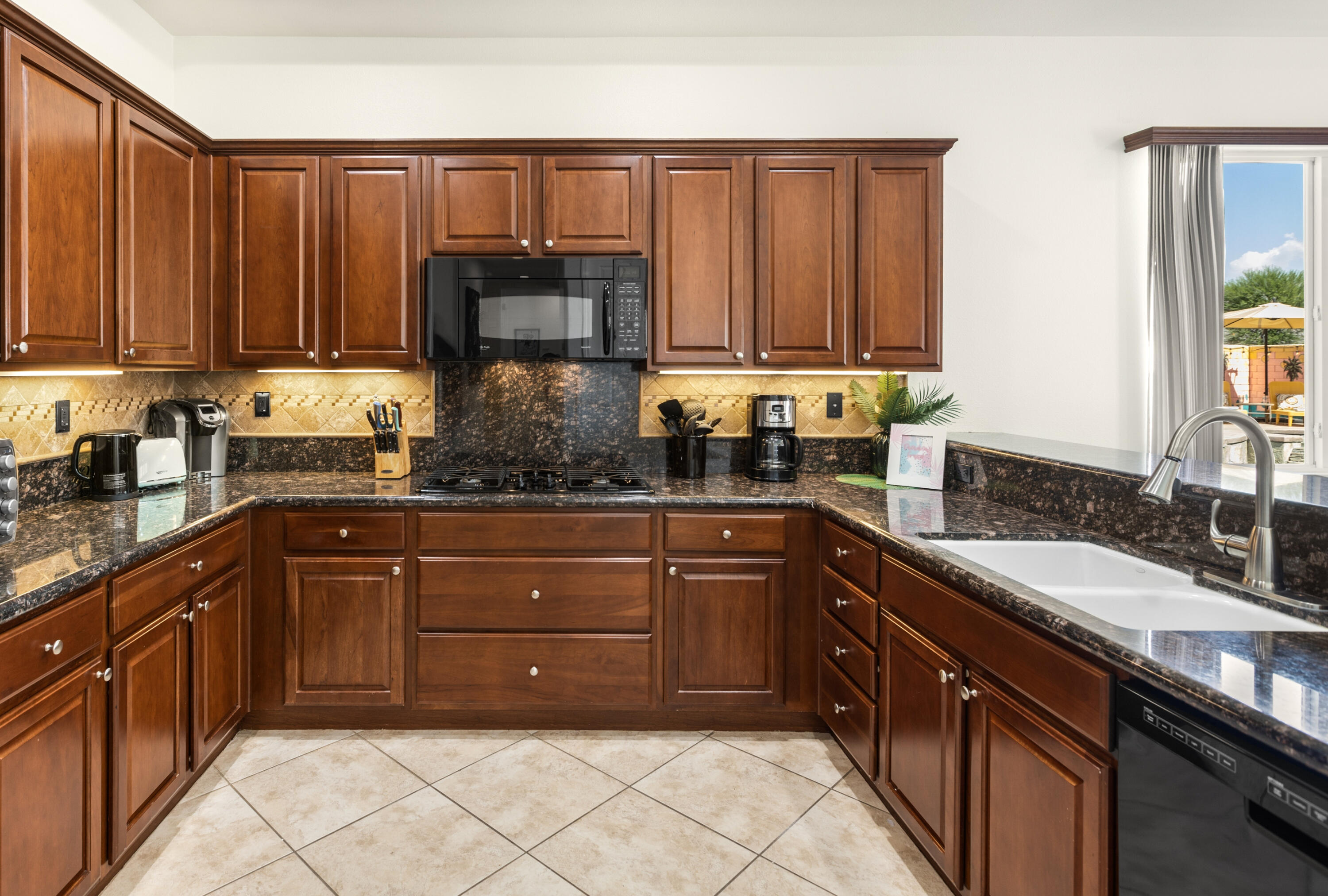 43760 Spiaggia Place Indio, CA 92203 - Photo 16 of 38 a kitchen with a sink and a stove