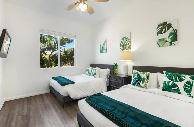 a bedroom with two beds and a window