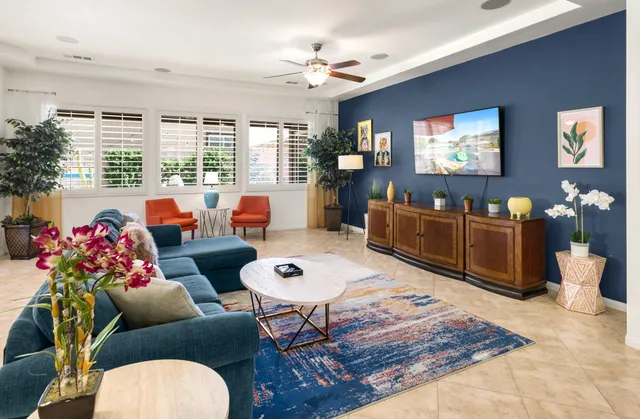 a living room with furniture a chandelier and a dining table