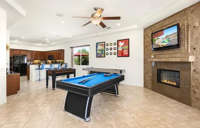 a living room with furniture pool table and a fireplace