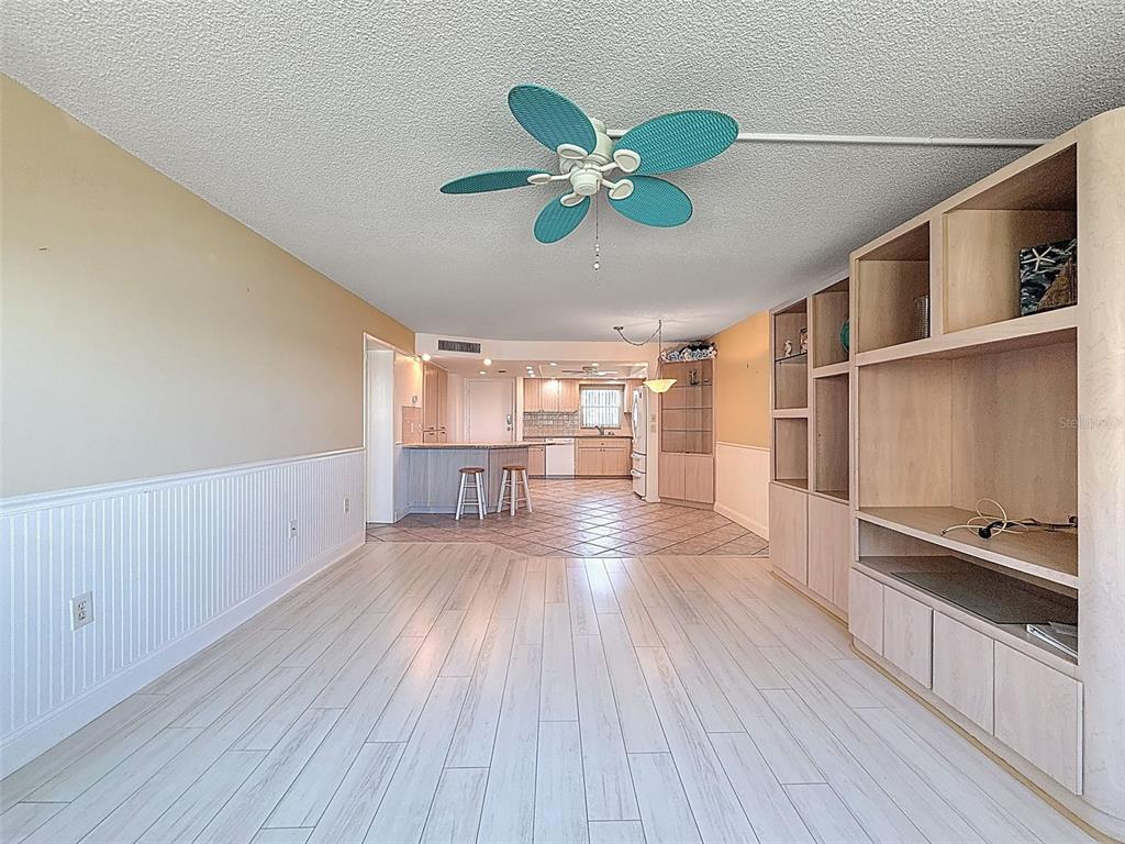 4550 Cove Circle, Unit 507 St. Petersburg, FL 33708 - Photo 12 of 32 a view of a hallway with wooden floor and a ceiling fan