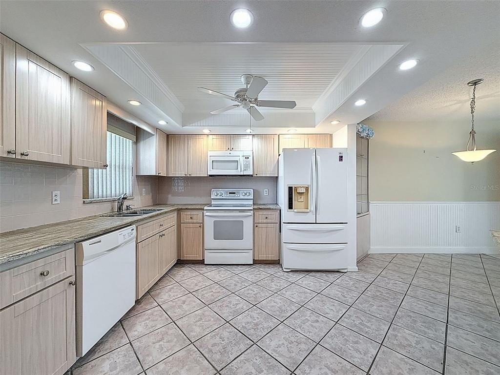 4550 Cove Circle, Unit 507 St. Petersburg, FL 33708 - Photo 2 of 32 a kitchen with white cabinets and white appliances