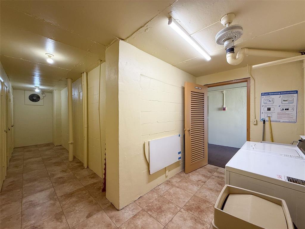 4550 Cove Circle, Unit 507 St. Petersburg, FL 33708 - Photo 21 of 32 a bedroom with a bed and a chandelier