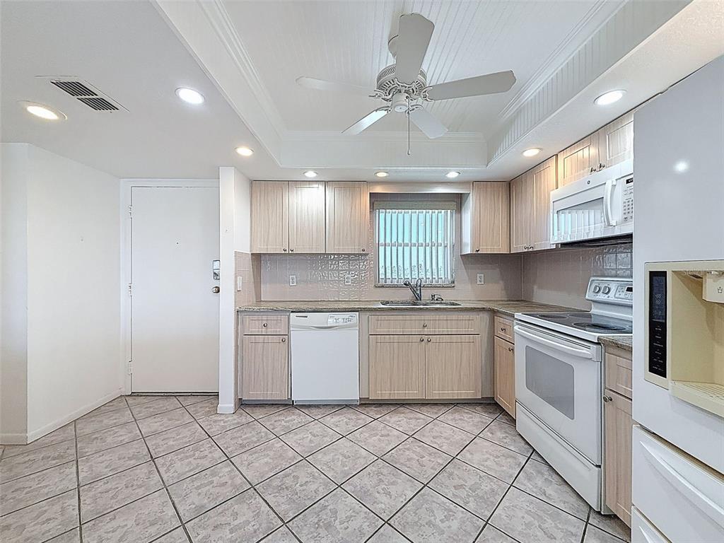 4550 Cove Circle, Unit 507 St. Petersburg, FL 33708 - Photo 5 of 32 a kitchen with a sink window and cabinets