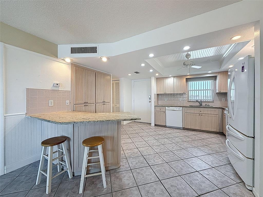 4550 Cove Circle, Unit 507 St. Petersburg, FL 33708 - Photo 6 of 32 a kitchen with cabinets and chair