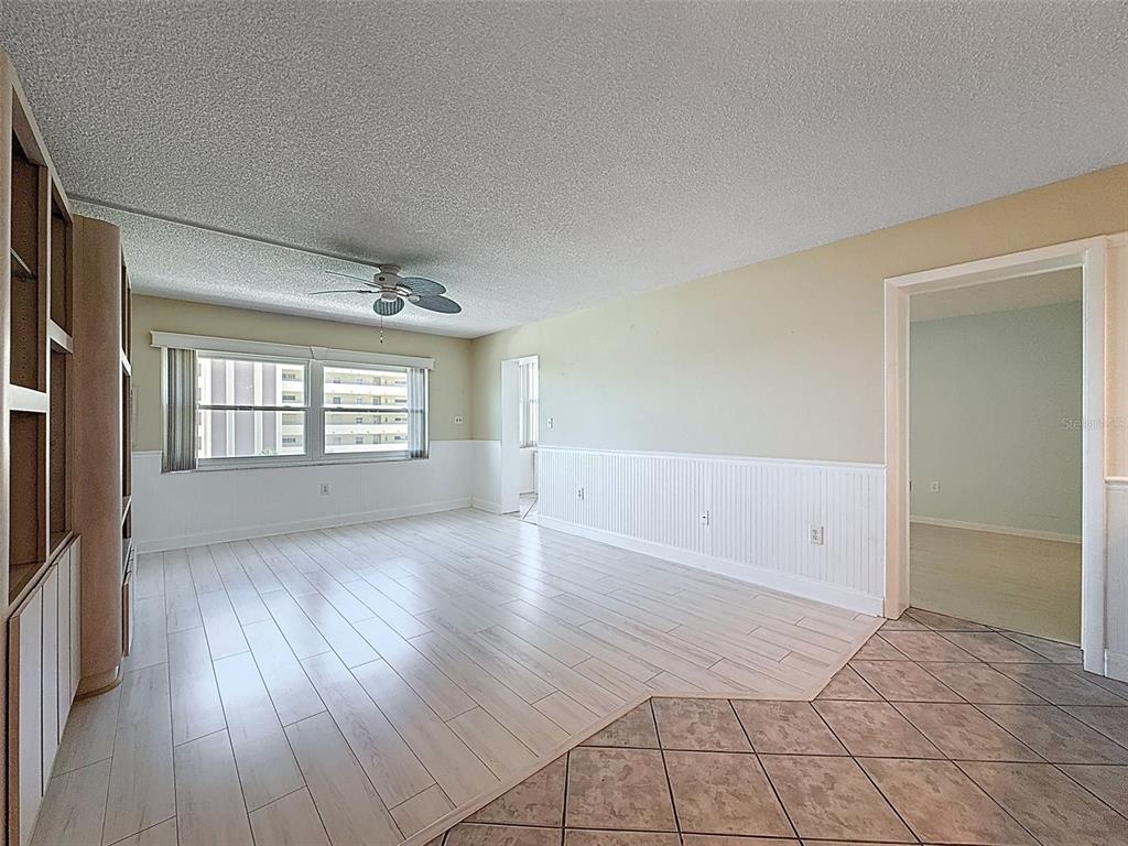 4550 Cove Circle, Unit 507 St. Petersburg, FL 33708 - Photo 10 of 32 an empty room with wooden floor cabinet and windows