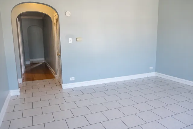 a view of a hallway with wooden floor and a bathroom