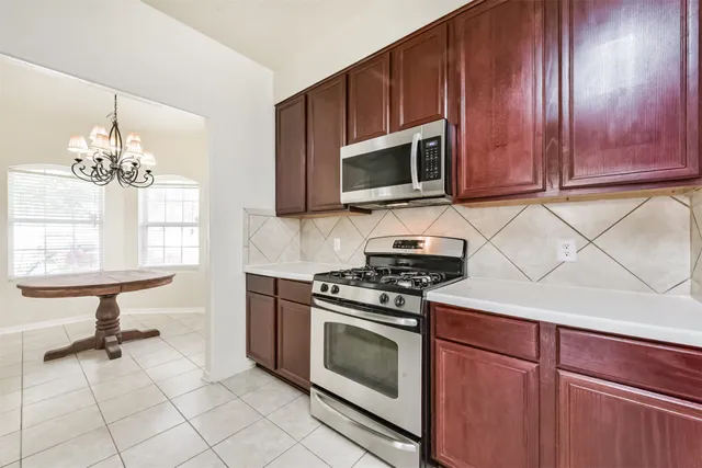 a kitchen with granite countertop a sink cabinets and stainless steel appliances