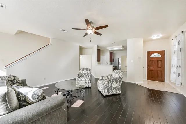 a living room with furniture and a wooden floor