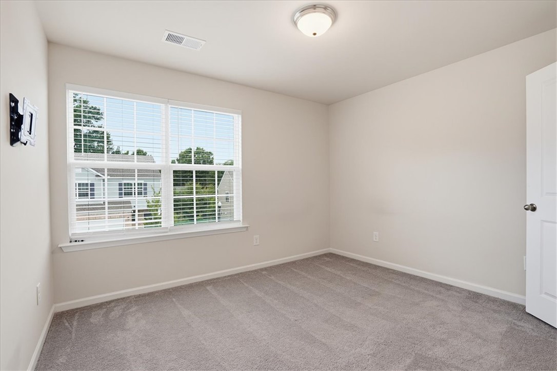 365 Sliding Rock Drive Pendleton, SC 29670 - Photo 17 of 46 A well-lit bedroom features plush carpeting and a wide window offering views of the neighborhood.