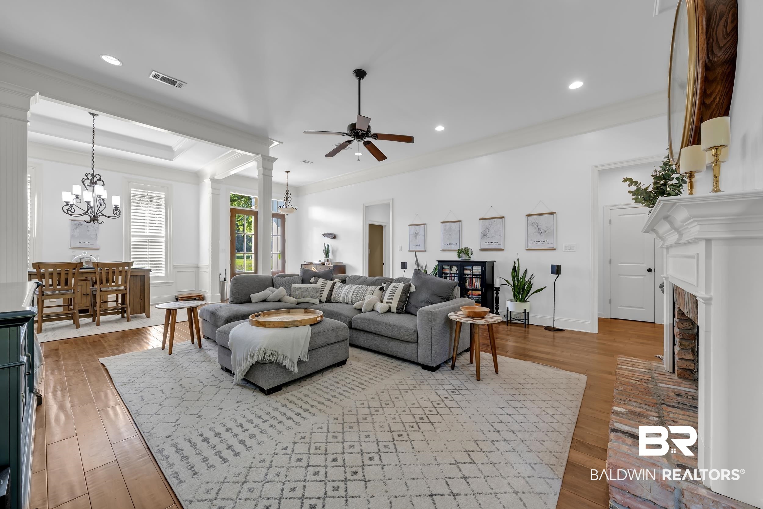 8137 Pine Run Daphne, AL 36527 - Photo 13 of 67 Spacious living room featuring wood-finish flooring, a white mantel fireplace with brick surround, and a ceiling fan