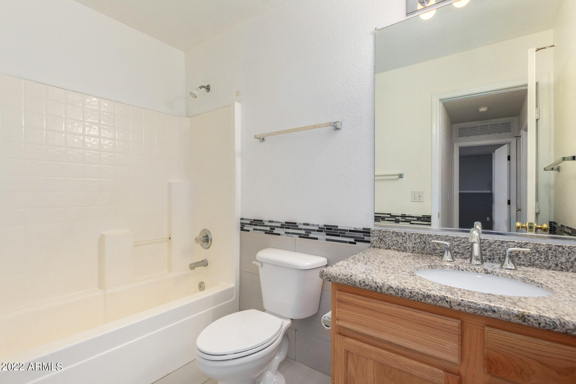 3307 South Bowman Road Apache Junction, AZ 85119 - Photo 22 of 28 a bathroom with a granite countertop sink a toilet a mirror and shower