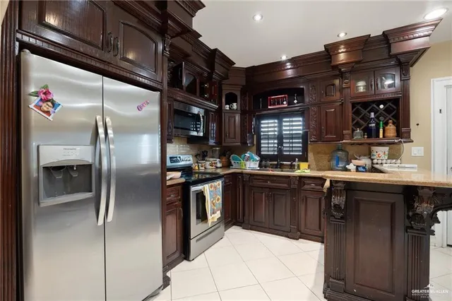 a kitchen with stainless steel appliances granite countertop a sink and a refrigerator
