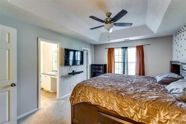 a bathroom with a granite countertop sink a toilet and a window