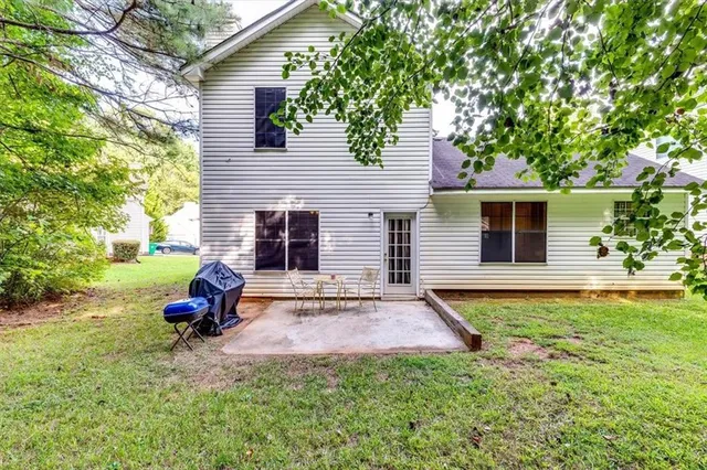 a view of a house with backyard and sitting area