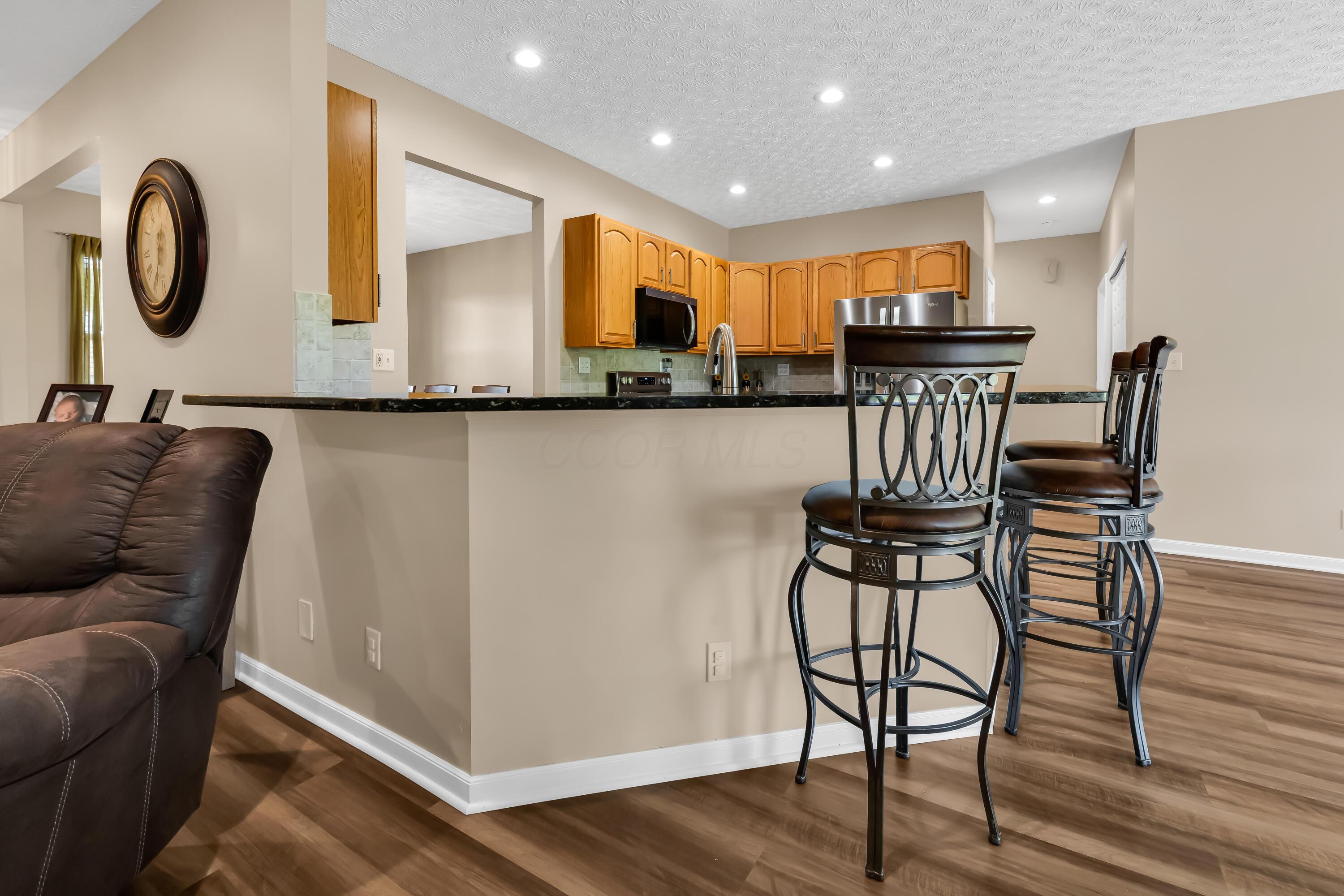 14396 Blamer Road Johnstown, OH 43031 - Photo 12 of 48 • Luxury vinyl plank flooring
• Tan painted walls
• Granite countertops
• New Whirlpool® refrigerator
~ 2025
• New Whirlpool® microwave
~ 2025
• New Whirlpool® electric
range ~ 2025
• New Whirlpool® dishwasher
~ 2025
• Peninsula with breakfast bar
ledge
• Double bowl, stainless steel
sink with sprayer
• New disposal ~ 2026
• Tile backsplash
• Raised panel cabinets