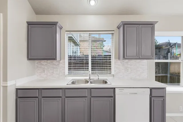 a kitchen with stainless steel appliances white cabinets and a window