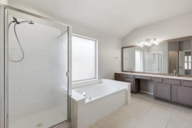 a bathroom with a tub sink and mirror