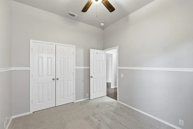 an empty room with chandelier fan