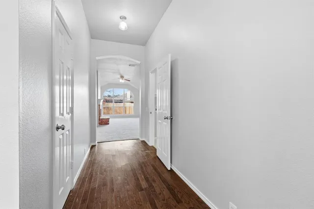 a view of a hallway with wooden floor