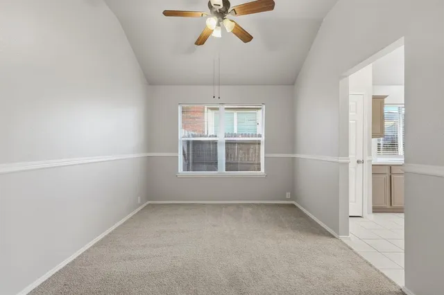 an empty room with a window and a ceiling fan
