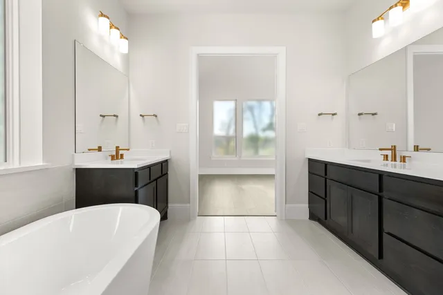 a bathroom with a tub sink shower and mirror