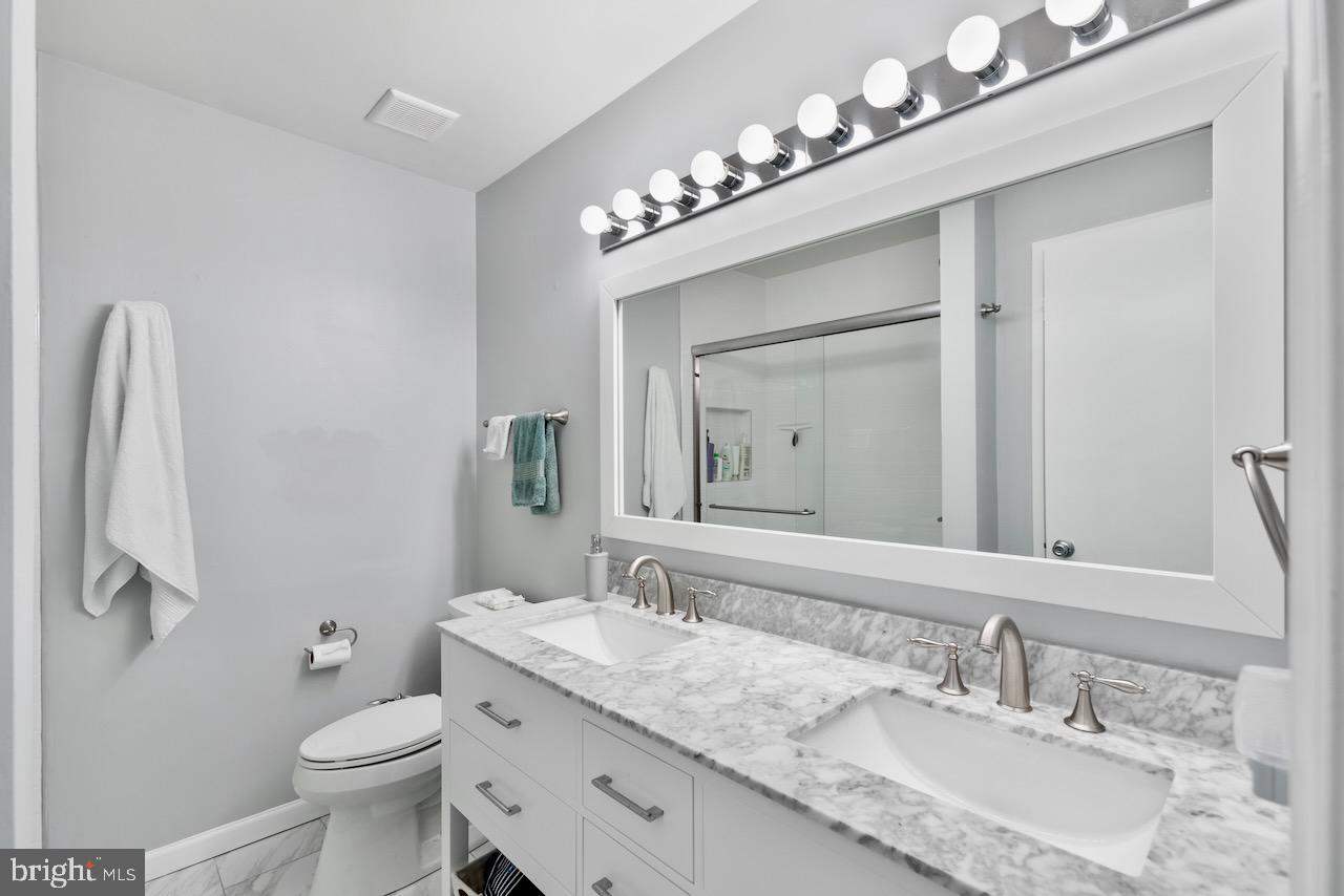 2224 Wheelwright Court Reston, VA 20191 - Photo 17 of 32 a bathroom with a granite countertop sink a toilet and a mirror