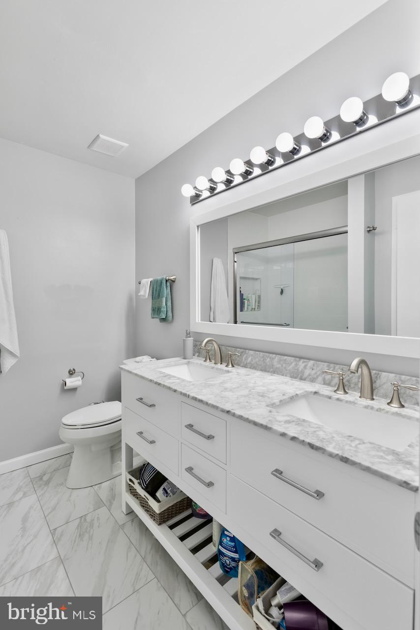 2224 Wheelwright Court Reston, VA 20191 - Photo 18 of 32 a bathroom with a granite countertop toilet sink and mirror