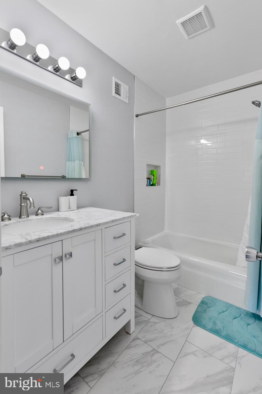 2224 Wheelwright Court Reston, VA 20191 - Photo 21 of 32 a bathroom with a toilet a sink a mirror a bathtub and vanity