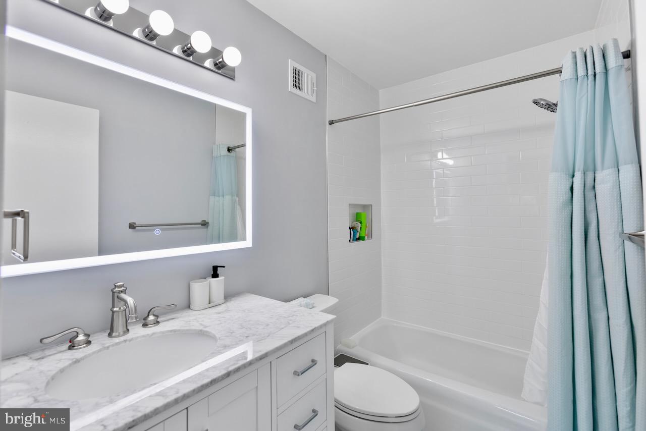 2224 Wheelwright Court Reston, VA 20191 - Photo 22 of 32 a bathroom with a granite countertop sink a toilet and shower