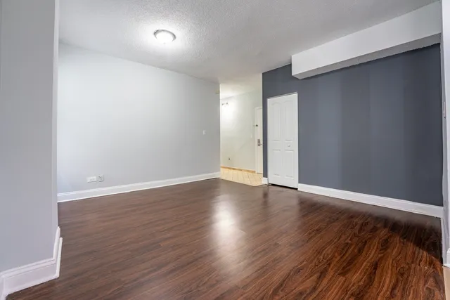 a view of an empty room with wooden floor