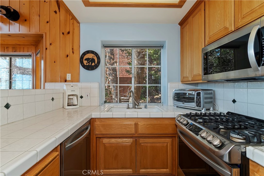 2477 Spring Oak Drive Running Springs, CA 92382 - Photo 18 of 51 a kitchen with stainless steel appliances granite countertop a stove a sink and a microwave