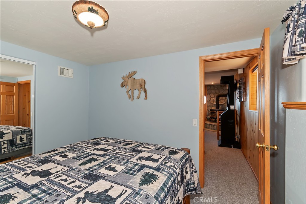 2477 Spring Oak Drive Running Springs, CA 92382 - Photo 42 of 51 a bedroom with a bed and a chandelier