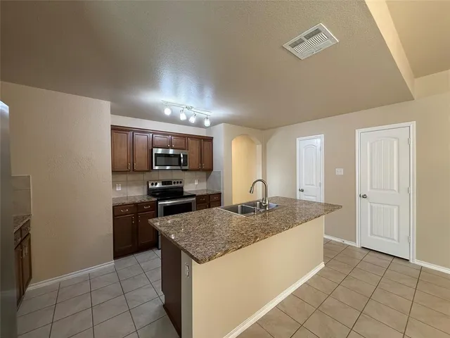 a kitchen with a stove a sink and a refrigerator