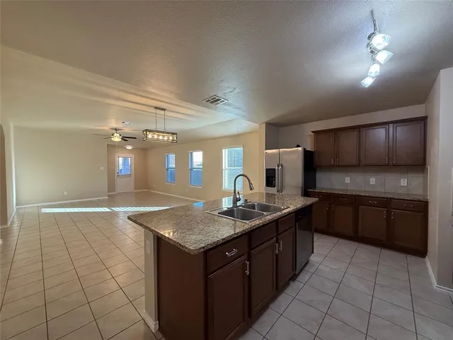 a kitchen with a sink a counter top space appliances and cabinets