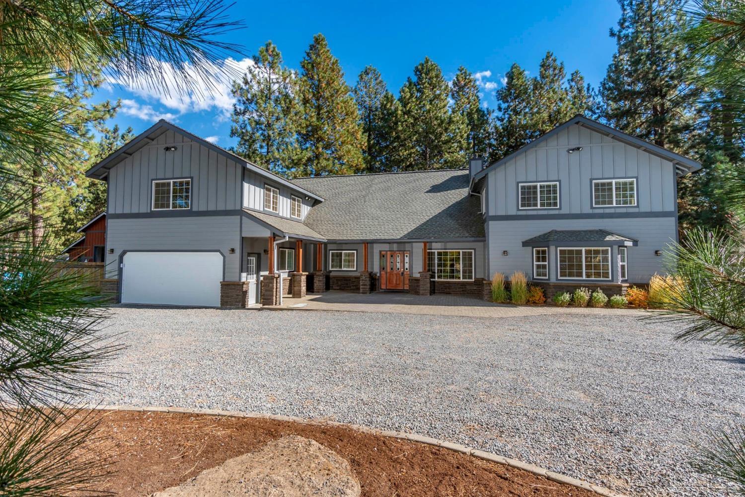 60098 Cinder Butte Road Bend, OR 97702 - Photo 1 of 25 a front view of a house with a yard and garage