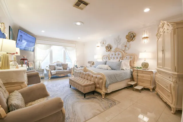 a spacious bedroom with a bed a couch and dresser