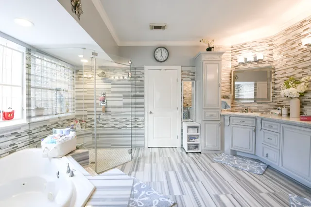 a bathroom with a sink a large mirror and a bathtub