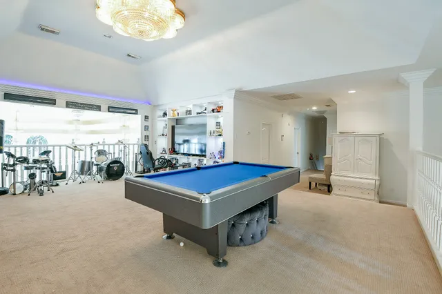 a room with pool table and a chandelier